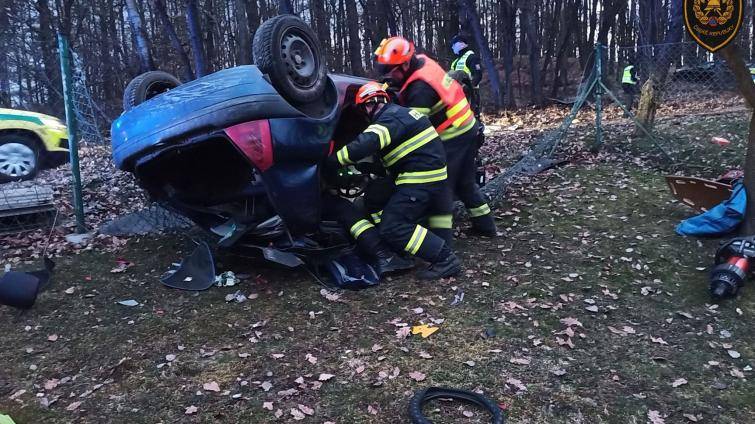 Osobní vozidlo prorazilo plot a skončilo převrácené na střeše