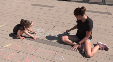 Děti malovaly křídami na chodníku před knihovnou 